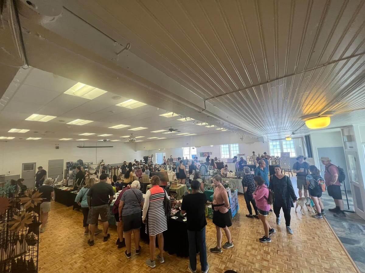 image of indoor craft fair with people shopping at booths