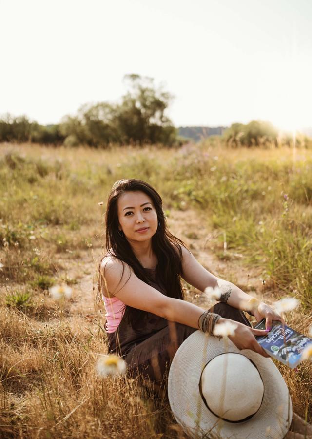 Picture of woman sitting in a grassy, sunny field
